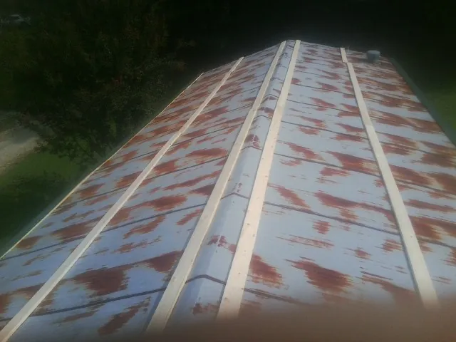 Rusted metal roof panels with new wood purlins before replacement — Storm Damage Roof Repair in Jetson by Roofing Brothers