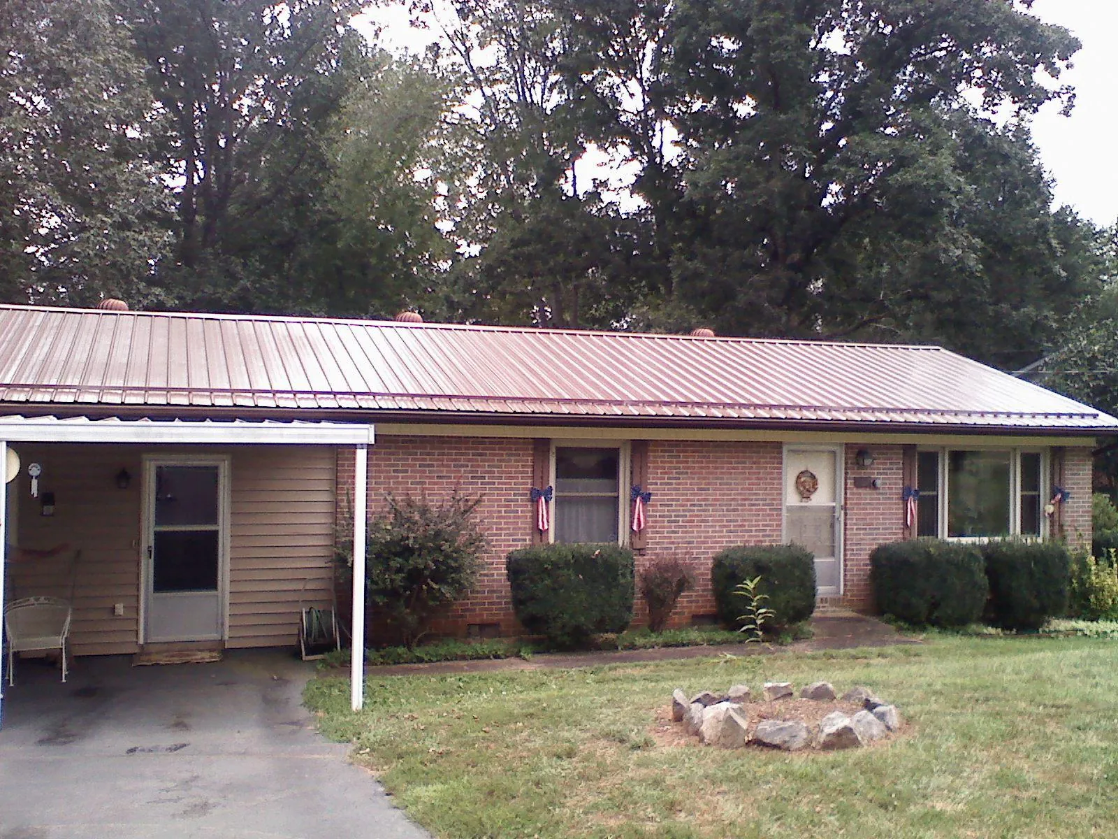 Bronze metal roof and carport on a brick ranch home — Roof Repair work by our crew in Jetson